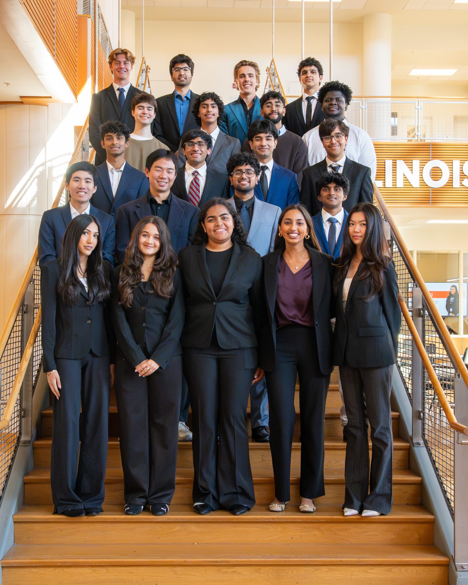 The Founders team posing on a staircase in business attire